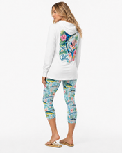 Load image into Gallery viewer, A woman modeling a white long-sleeve Reel Mermaid Tropical Marlin hooded top and Bluewater Bloon printed capri leggings from the back, showing a large multicolor floral graphic on the back of the top and a blue Reel Mermaid logo. The leggings have a blue, pink, and yellow tropical fish pattern.